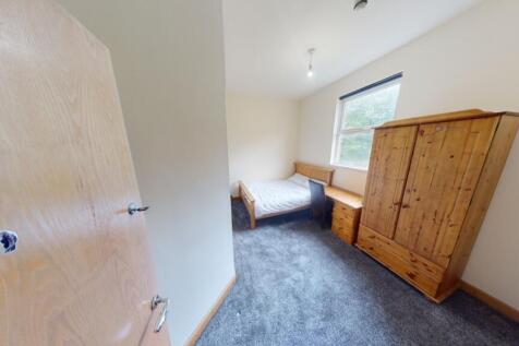 A cozy single bedroom featuring a comfortable b...