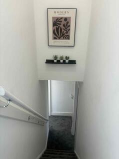 A modern staircase with a white wall adorned wi...
