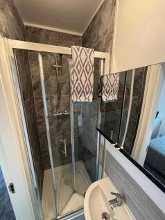 A modern bathroom featuring a glass-enclosed sh...