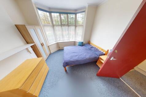 A bright double bedroom featuring a large bay w...