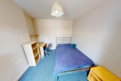 Cozy single bedroom with a blue carpet and a si...