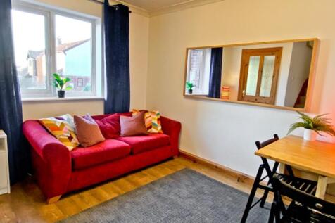 This inviting living room features a cozy red s...