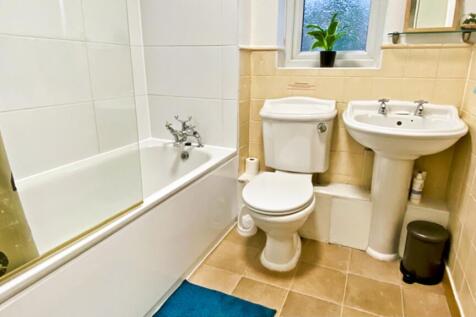 A well-maintained bathroom featuring a bathtub ...