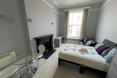 A spacious master bedroom featuring a large win...