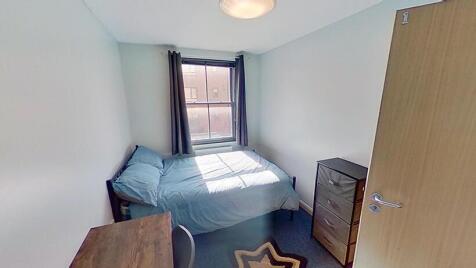 Cozy single bedroom featuring a comfortable bed...