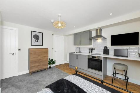 This stylish double bedroom features a cozy des...