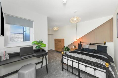 This stylish double bedroom features a comforta...