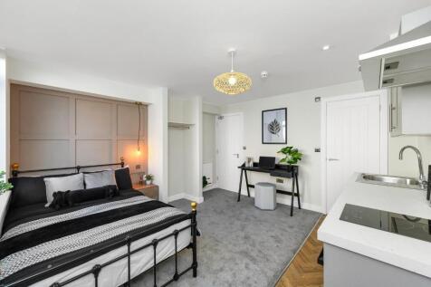 This stylish double bedroom features a cozy bed...