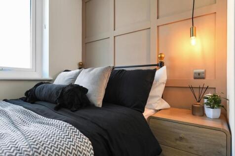 This cozy double bedroom features a stylish des...