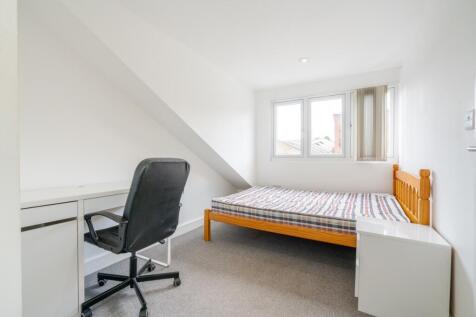 A bright and tidy single bedroom featuring a co...