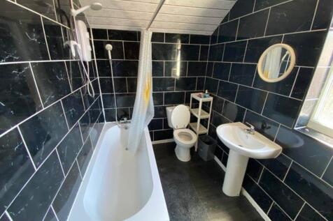 A stylish and modern large bathroom featuring a...