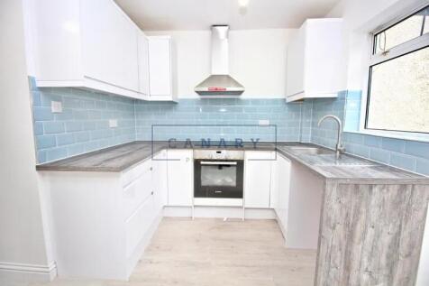 Bright and modern kitchen featuring clean white...