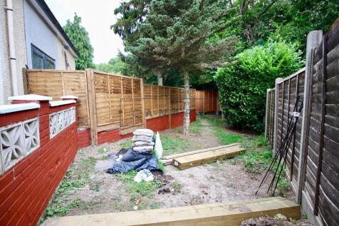 A garden space bordered by wooden fences and lu...