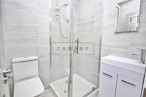 Bright and modern bathroom featuring a glass-en...