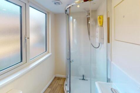 A modern bathroom featuring a spacious shower, ...