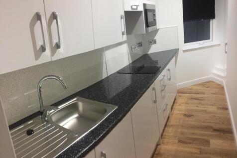 A modern kitchen featuring clean white cabinetr...