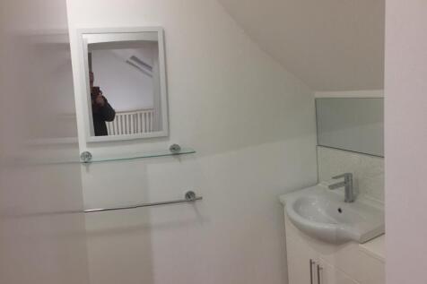 A clean, modern bathroom with white walls, a co...