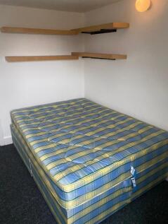 A spacious double bedroom with ample shelving, ...