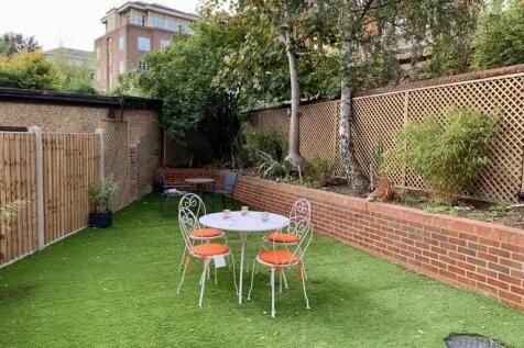 A well-maintained garden featuring a neat artif...
