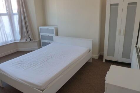 A bright and tidy single bedroom featuring a co...