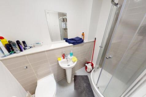 A modern bathroom featuring a spacious shower e...
