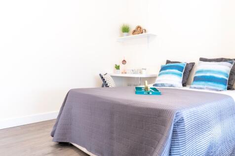 This inviting double bedroom features a cozy at...