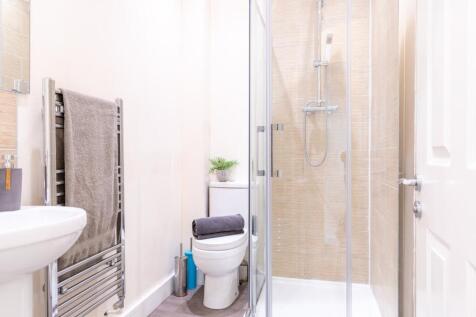 A modern bathroom featuring a sleek glass showe...
