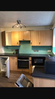 Spacious kitchen featuring modern wooden cabine...