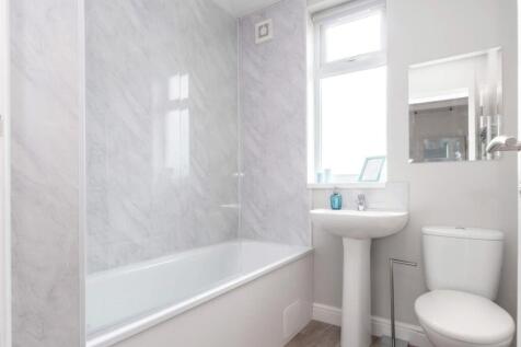 Bright and clean bathroom suite featuring a mod...