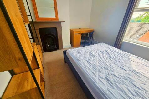 A bright and tidy bedroom featuring a comfortab...