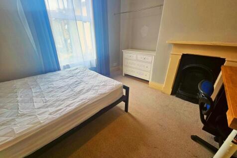 A bright and inviting bedroom featuring a neatl...