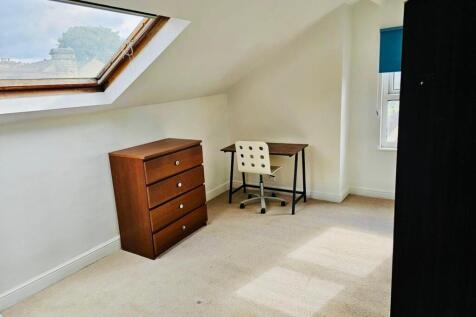 Bright and tidy bedroom featuring a wooden dres...