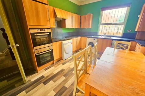 A well-lit and tidy kitchen area featuring wood...