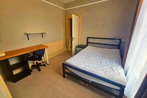 A cozy single bedroom with a neatly made bed an...