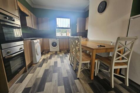 A modern kitchen area featuring a wooden dining...