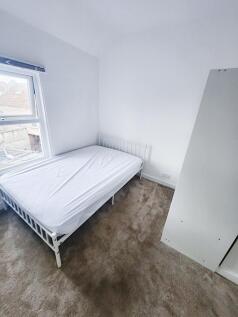 Bright, freshly painted bedroom with a white me...