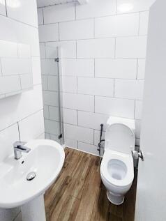 Bright, modern bathroom with white tiled walls,...