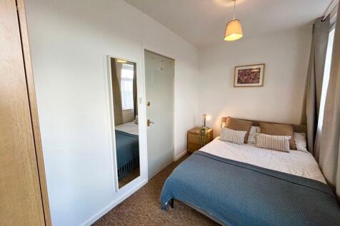 This cozy double bedroom features a comfortable...