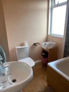 Bright and tidy bathroom featuring a bathtub an...