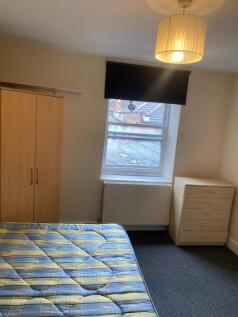 A simple and clean single bedroom with a large ...