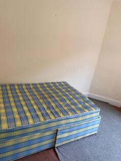 A simple single bedroom featuring a patterned m...
