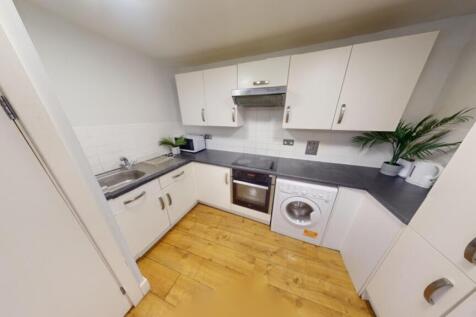 A modern and tidy kitchenette with ample storag...