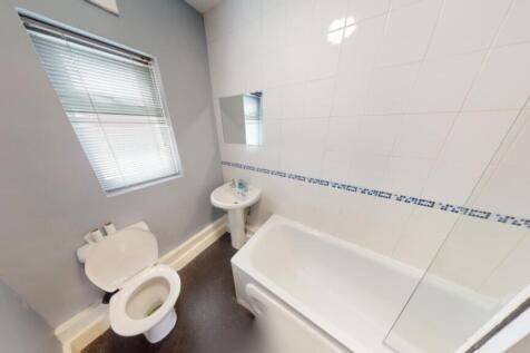 A bright and tidy bathroom featuring a bath and...