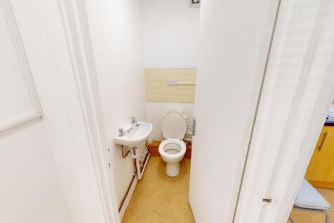 A tidy single toilet with essential amenities, ...