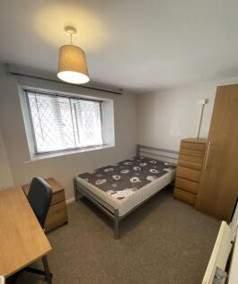 A tidy single bedroom featuring a comfortable b...