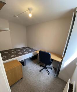 A well-kept single bedroom featuring a comforta...