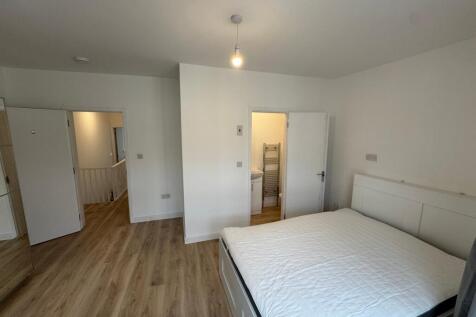 This spacious double bedroom features a comfort...