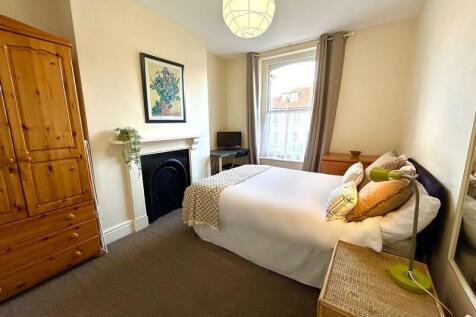 A charming double bedroom featuring a cozy bed,...