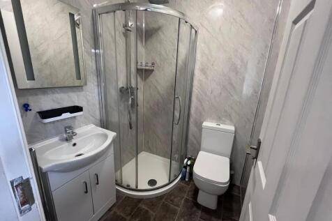 A bright and modern bathroom featuring a curved...