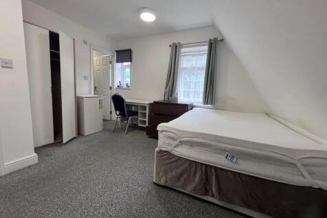 A tidy single bedroom featuring a comfortable b...